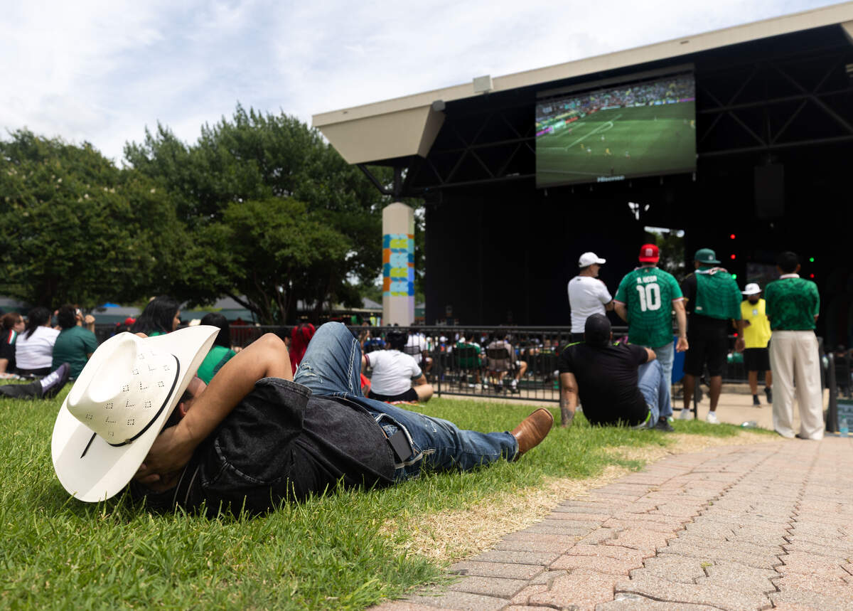 Kevin Reyes lies on grass while watching Mexico face off against South Africa during the FIFA Fan Festival on Thursday, June 11, 2026, at Fair Park in Dallas. Mexico's game against South Africa's began at 2 p.m.