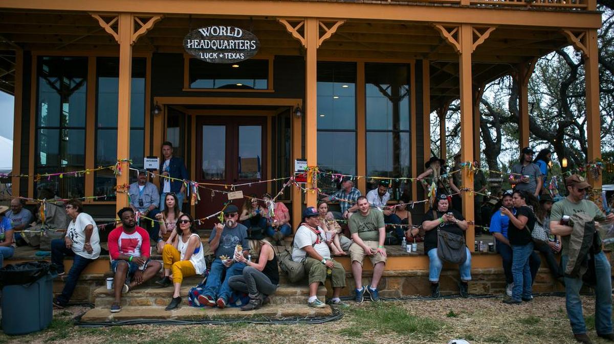Fest-goers wait while a rain delay is called during the Luck Reunion at Willie Nelson's Ranch in Spicewood, Texas on Friday, March 17, 2016.