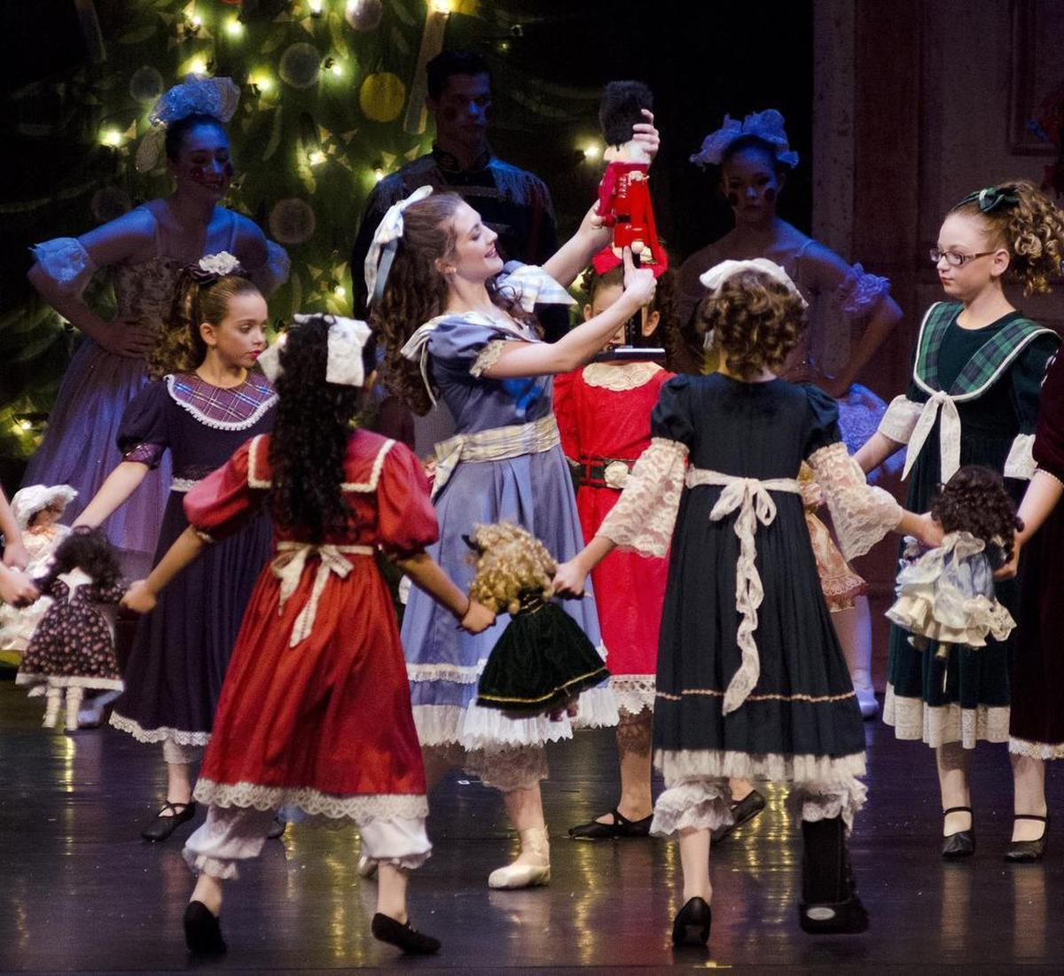 Courtney Noetzel as Clara holds a nutcracker as children dance around her in act one of the North Central Ballet's performance of "The Nutcracker."