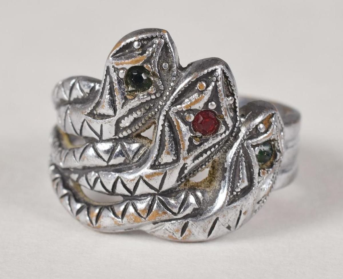 Bonnie Parker's silver-toned three-headed snake ring featuring green and red jewels was once thought to have been crafted for her by Clyde Barrow while he was imprisoned in Texas.