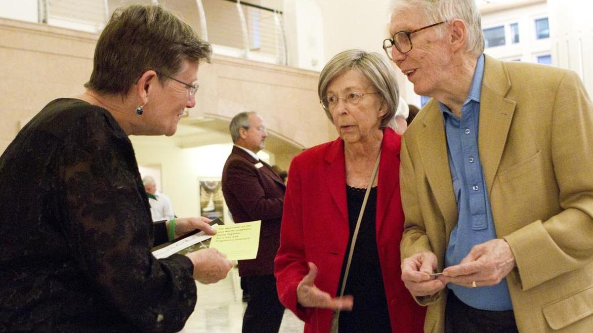 Joni Baczewski with the Fort Worth Symphony Orchestra hands out leaflets about contract negotiations to patrons Helen and Don Matheson.
