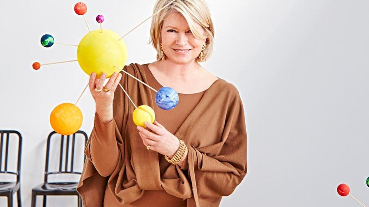 Martha Stewart holds a finished solar system craft the kids made at the party.