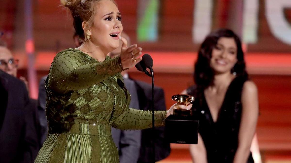 Adele wins album of the year for “25” at the 59th annual Grammy Awards. The singer also performed a tribute to George Michael on Sunday night.
