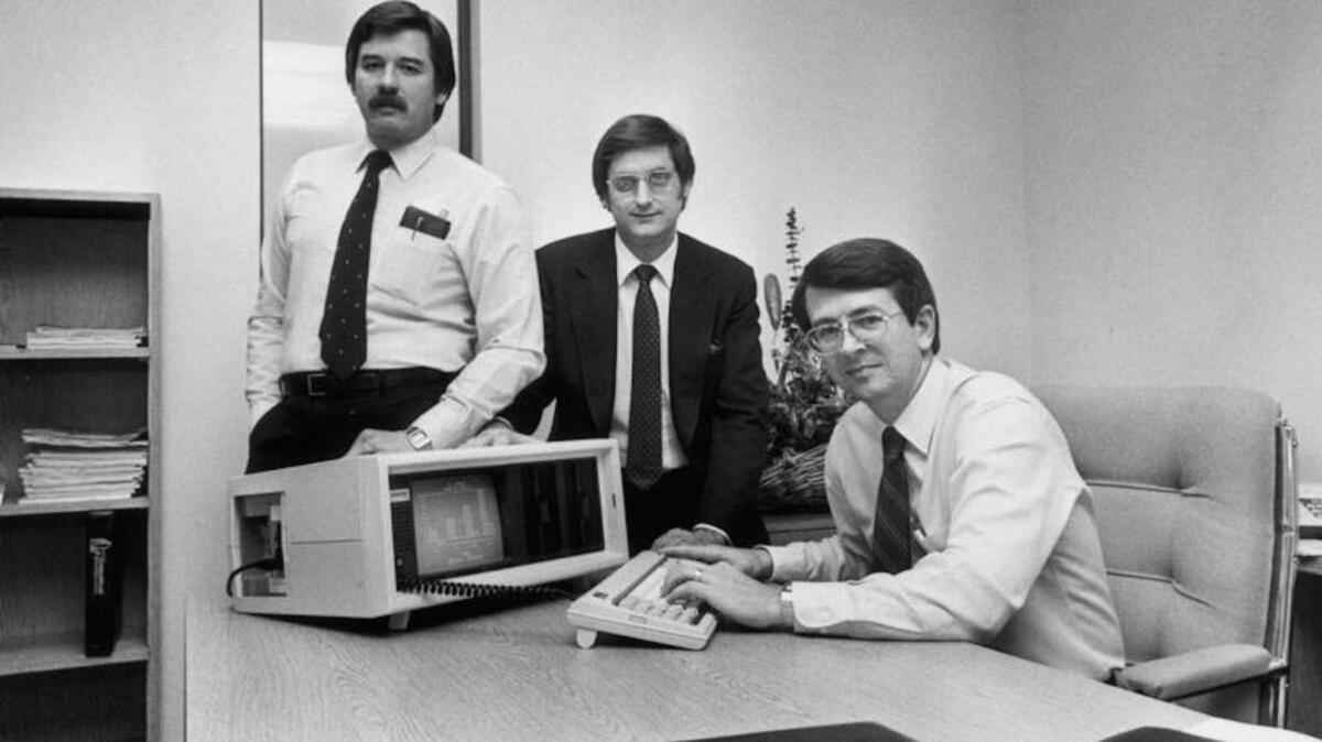 Kraftwerk or Compaq? It’s the latter. Compaq Computer Co-founders with the first Compaq portable computer. From left, Jim Harris, Bill Murto, Rod Canion