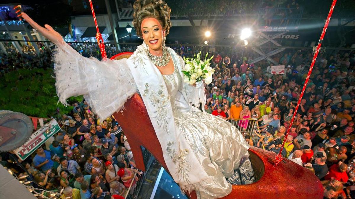 Female impersonator Gary Marion, known as Sushi, hangs in a giant replica of a woman’s high heel shoe in Key West, Fla., in the annual Big Red Shoe Drop.