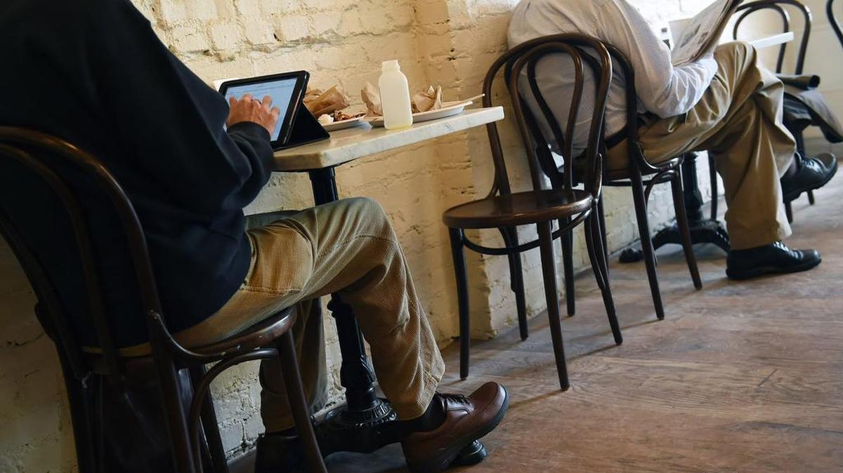 Patrons settle in with tablets and newspapers at an eatery in Washington.