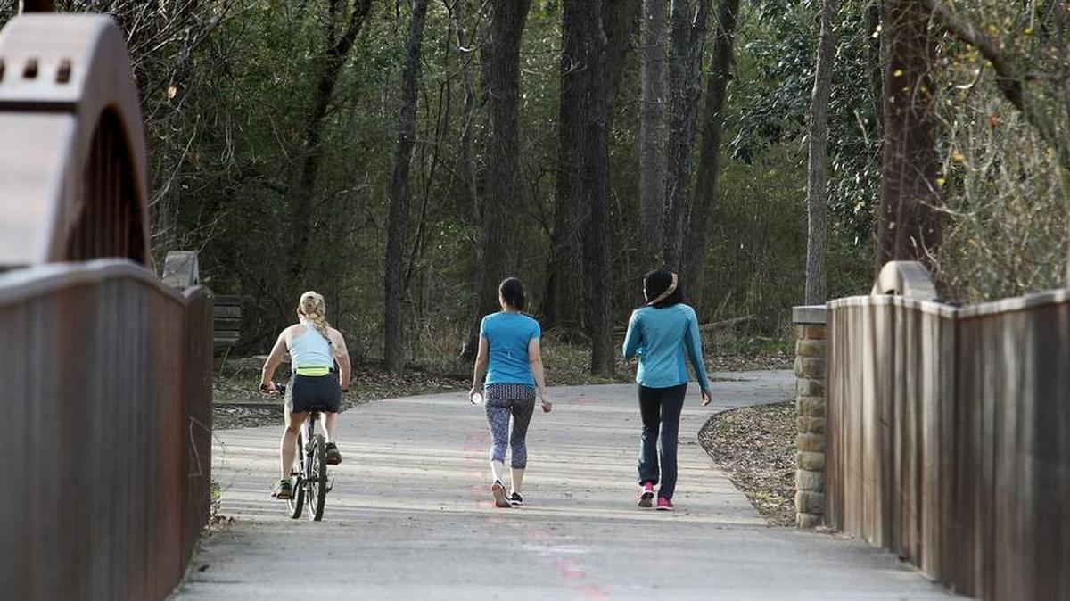 Walkers and a cyclist hit the trails at River Legacy Parks in Arlington.