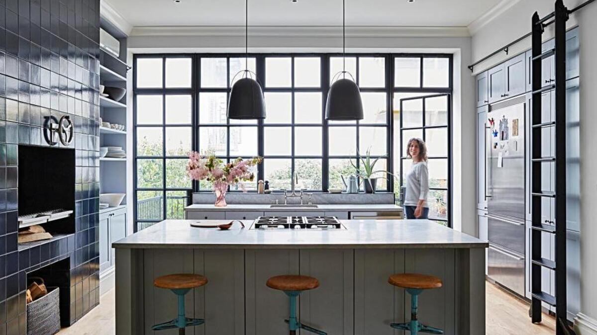 In their Brooklyn brownstone, Cristin Frodella and her husband, Conor Sheridan, wanted a wide-open kitchen where everyone could gather, and an indoor grill, left.