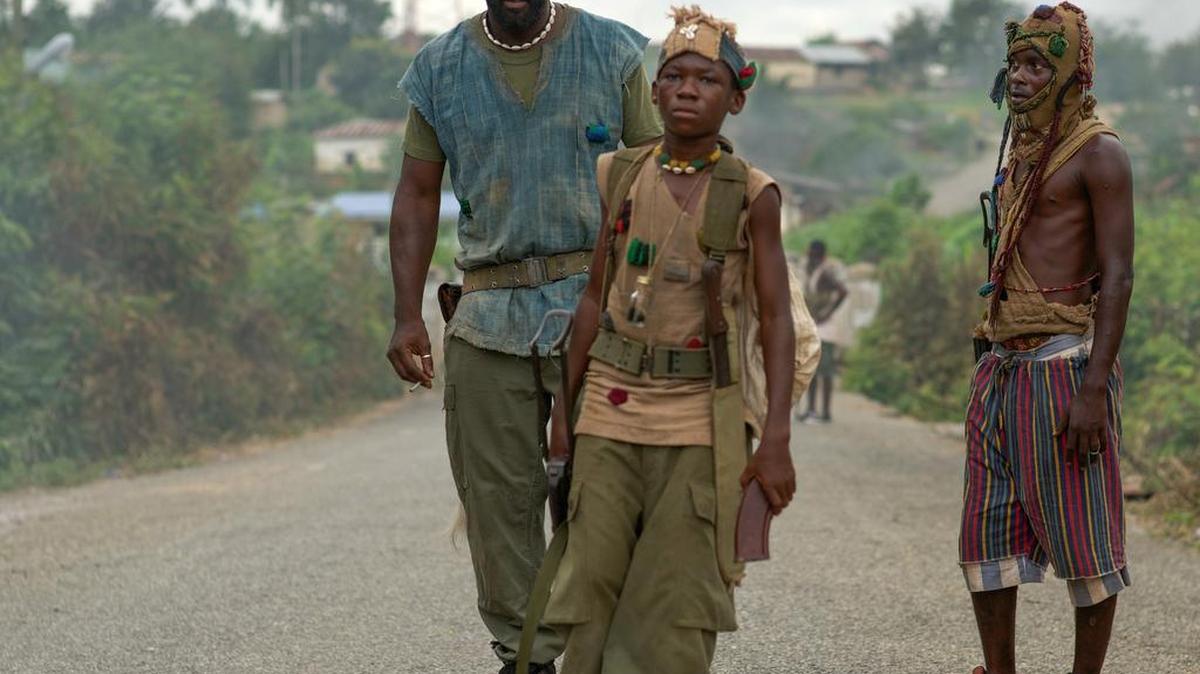 
Idris Elba, left, as Commandant, and Abraham Attah, center, as Agu in Beasts of No Nation



