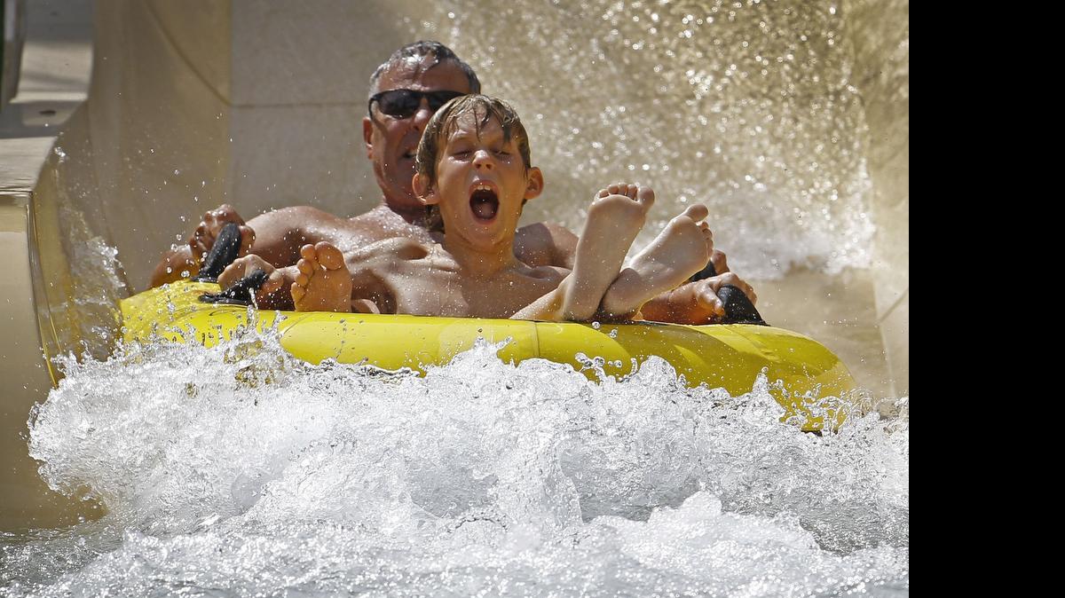 
Payton Miller, 9, lets out a yell while riding down the chute of the Green Extreme with grandfather Mark Miller, both from Fort Worth at NRH20 in North Richland Hills.
