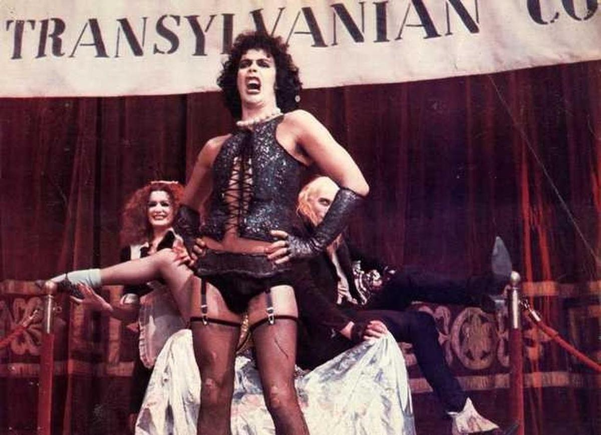 Tim Curry as Dr. Frank-N-Furter in 1975’s Rocky Horror Picture Show. In background are Patricia Quinn as Magenta and Richard O’Brien as Riff-Raff. 