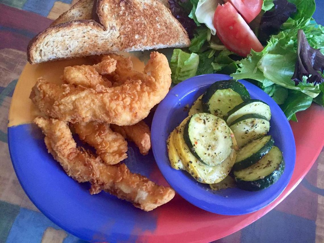 Spicy chicken tenders with zucchini and salad at Old Neighborhood Grill.