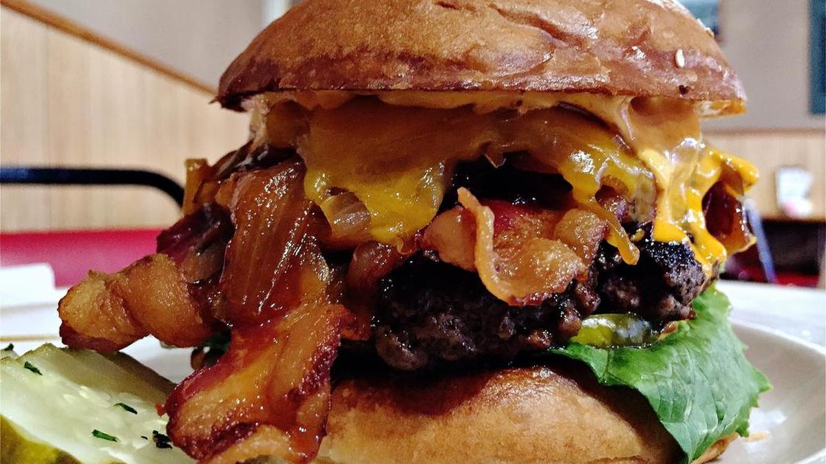 Swiss Pastry’s Killer Bee: A half-pound Akaushi beef patty between house-made brioche buns, topped with sweet yellow onions cooked in a mix of Texas honey, Sriracha sauce and red wine vinegar, with lots of bacon and cheese.