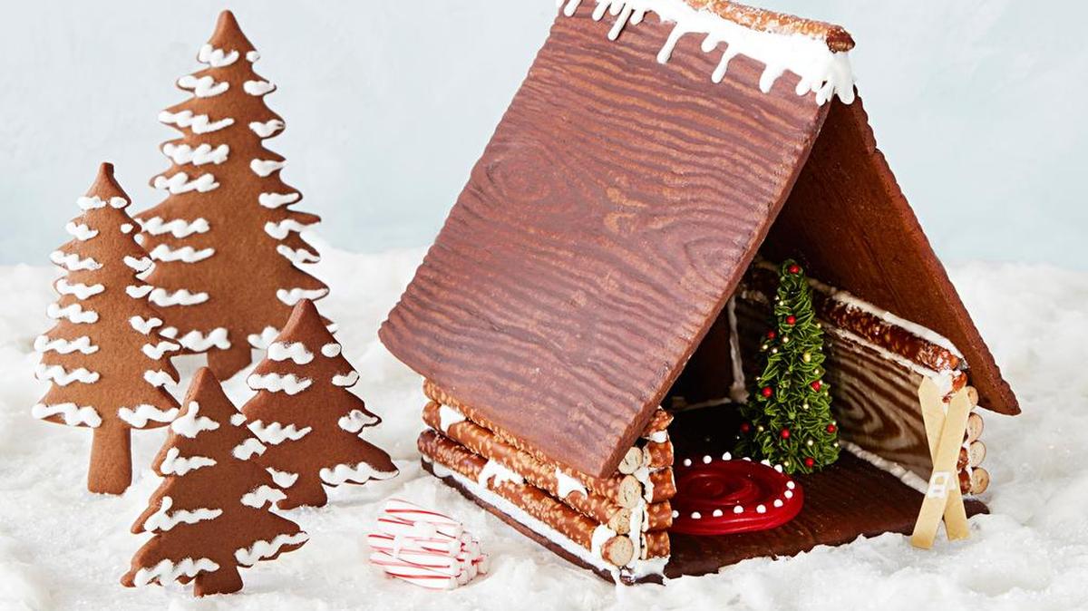 Landscape the place: To fashion a small forest of snow-dappled trees, roll out extra dough and cut, bake and ice it. Then add a pile of peppermint-stick firewood and gum-stick skis.
