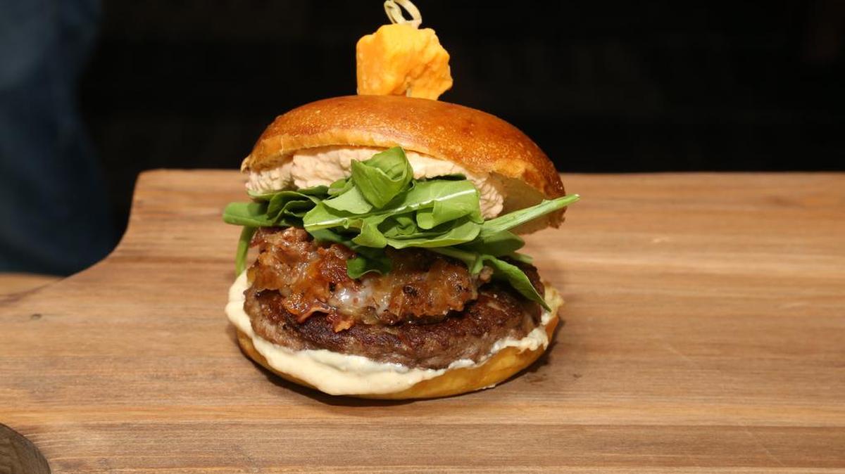 The Dirkburger: a one-third-pound beef burger on Bavarian pretzel bun, with jalapeño beer cheese, bacon onion marmalade, arugula and mustard horseradish aioli.