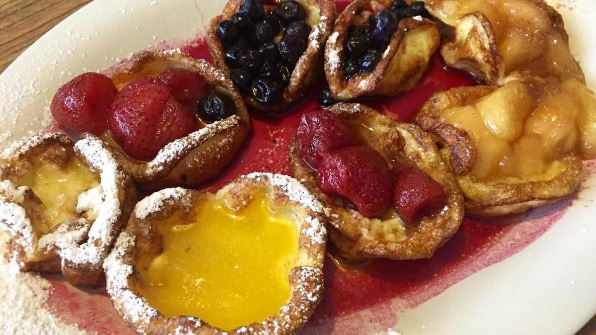 The “Dutch babies sampler” (lemon, strawberry, blueberry, apple) is listed as an appetizer at Ol’ South Pancake House.