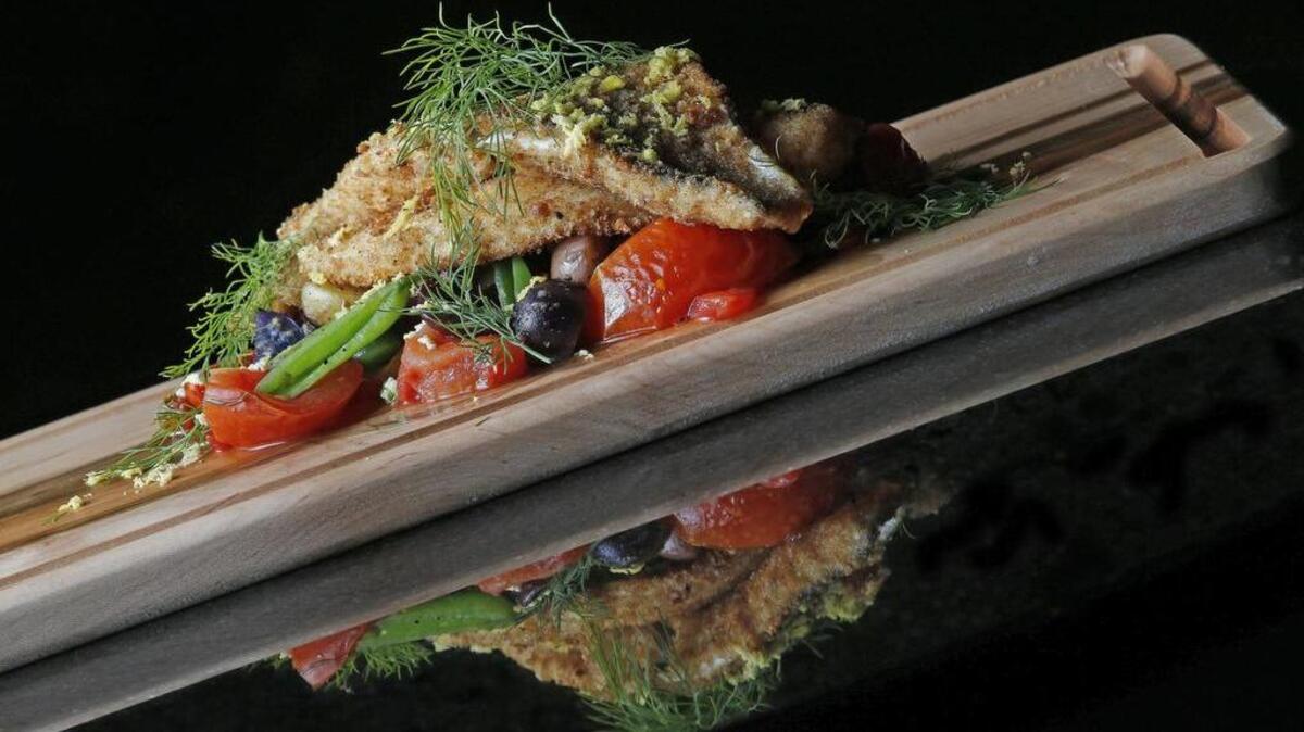 New Bird Cafe executive chef Scott Curtis prepared Crispy Mediterranian Branzini (with marble potatos, sugar snap peas, kalamata olives and chili poached tomatos)