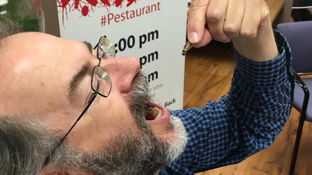 DFW.com/Star-Telegram reporter Robert Philpot gets ready to down a salt-and-vinegar cricket. Yes, he went through with it. Wonder why his eyes are closed?