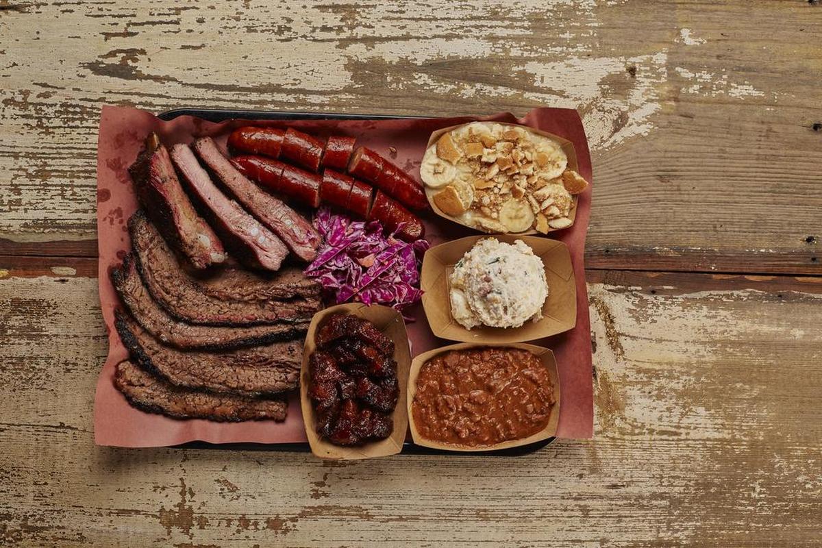 Clockwise from top left: ribs, sausage, banana pudding, potato salad, beans, bacon burnt ends and brisket from Heim Barbecue