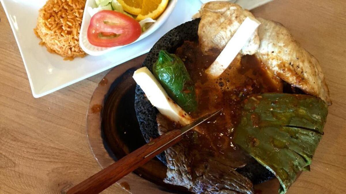 The molcajete filled with chicken, beef, chorizo and peppers at Chalios Mexican.