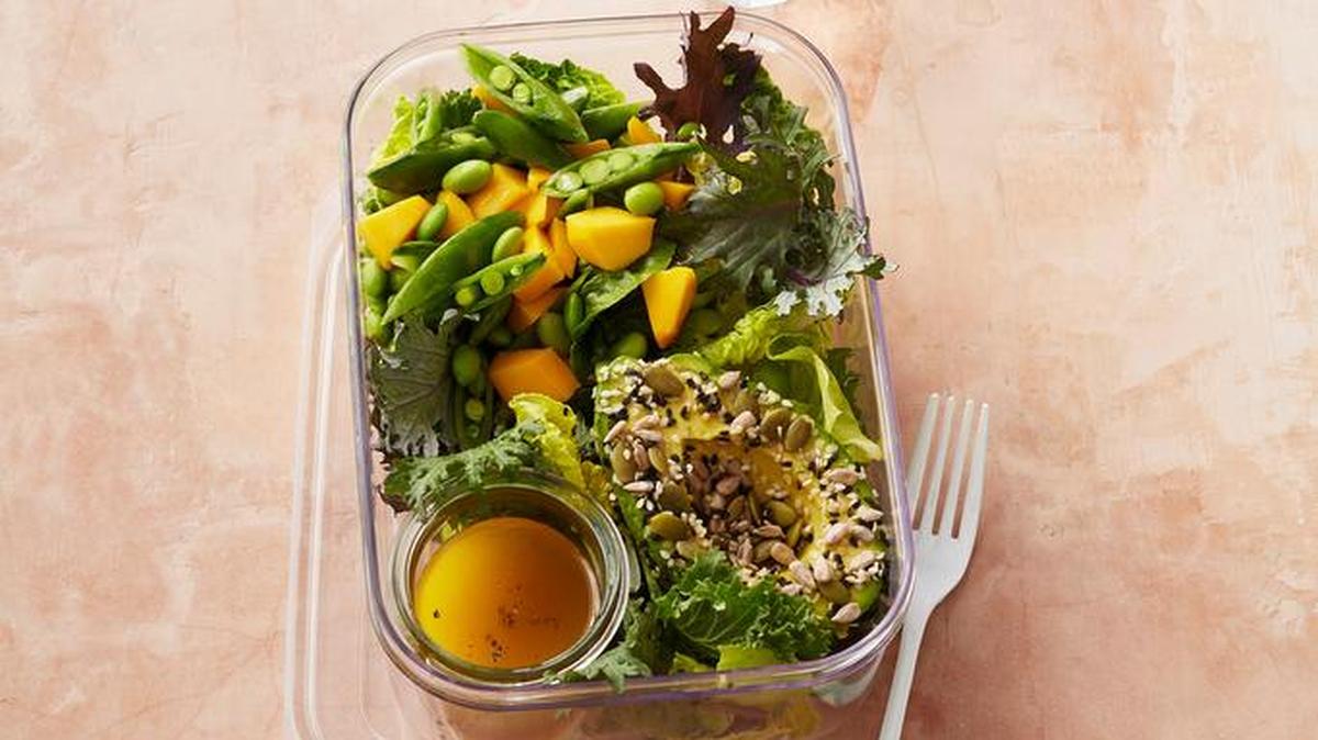 Make sure to leave extra space in the container for easy mixing. To avoid wilted greens, add dressing, salt and pepper just before eating, then cover and shake. (Bottom right) Coating the cut avocado half in seeds keeps the surface from browning.