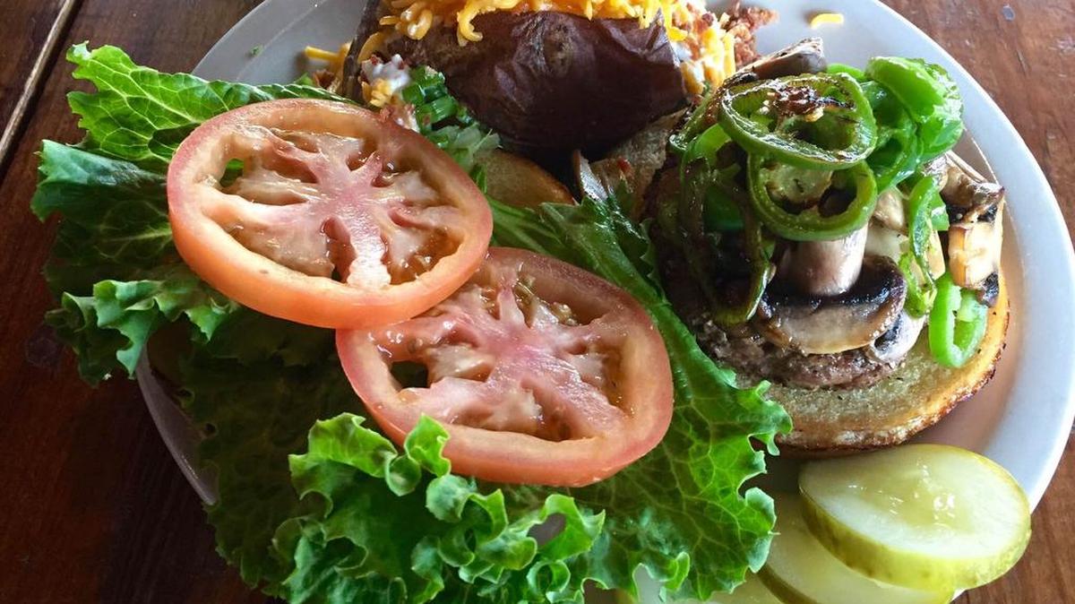 A burger with fresh-cut grilled jalapenos and baked potato at Buffalo West.