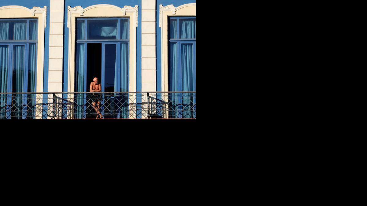 <137>In this Dec. 19, 2014 photo, a<137> Previously, only licensed travelers could visit Cuba.<252><137>A tourist looks out from his hotel room’s balcony in Havana, Cuba. In the past, people-to-people U.S. travelers could only go to Cuba under a license obtained by a travel company in a time-consuming process followed by lengthy government verification that travelers weren’t engaging in inappropriate leisure tourism. (AP Photo/Desmond Boylan) <252><137>