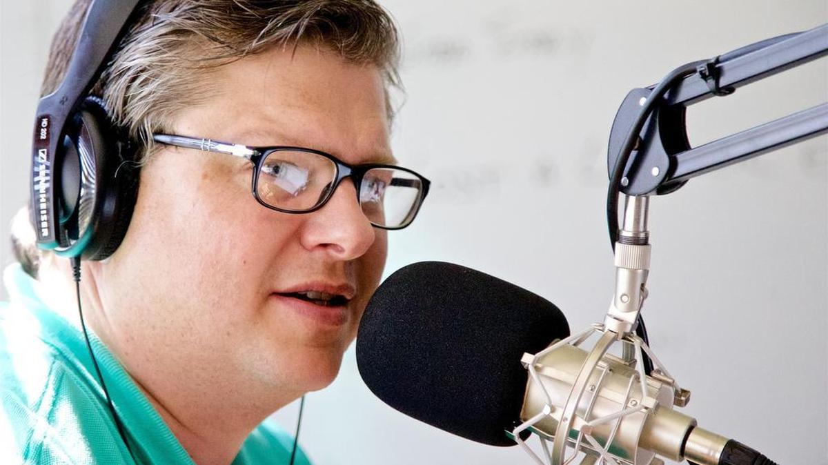 John Clay Wolfe in his Fort Worth studio during his Saturday-morning radio show. The show is syndicated on more than a dozen stations, and he hopes to increase the number to at least 25 by the end of 2016