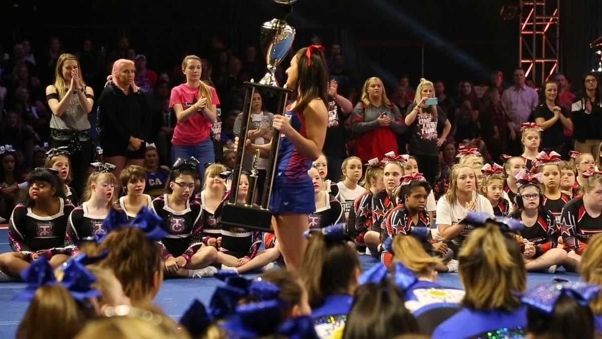 Members of the Texas Cheer Allstar squad eye the Superior trophy during the awards ceremony at the NCA All-Star National Championship in the special athlete division.