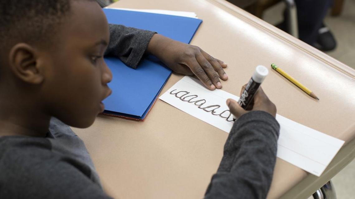 A third-grader practices his cursive handwriting at P.S.166 in the Queens borough of New York.