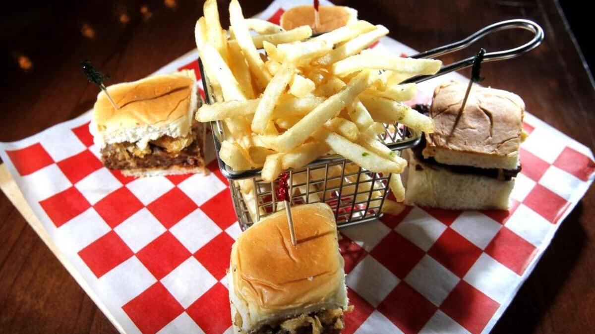 Meat loaf sliders with fried onion rings, and Shiner Bock cheese sauce at Reservoir