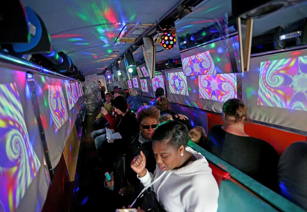 People ride the psychedelic Magic Bus tour in San Francisco, Calif.