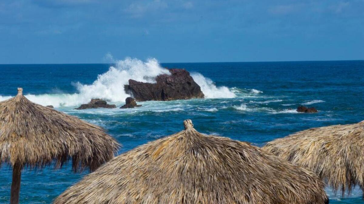 
On the Riviera Nayarit, a patio view at the Four Seasons Punta Mita Waves shows waves crashing over the offshore rocks. 
