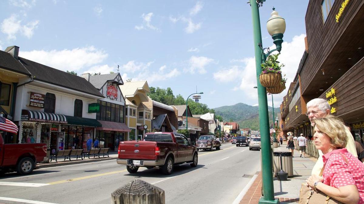 In this May 20, 2017 photo, people wait to cross the street in Gatlinburg, Tenn. A deadly wildfire in November 2016 put a dent in the tourism industry, but signs of growth are returning.