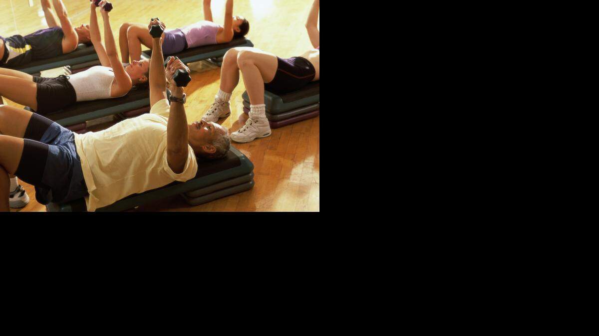 
High angle view of five people exercising in a step aerobics class
