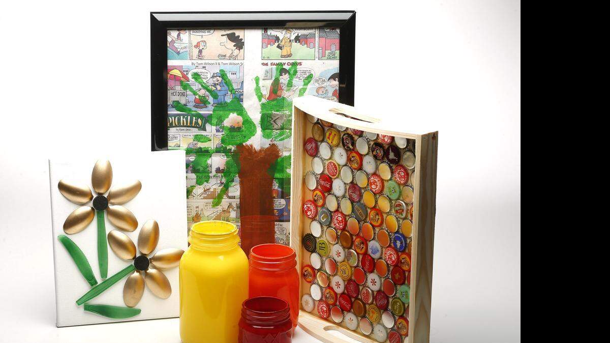 
Earth Day craft projects from left to right: 1970's styled 3D plastic spoon art, glass jar luminaries, newspaper handprint trees and a bottle cap serving tray.
