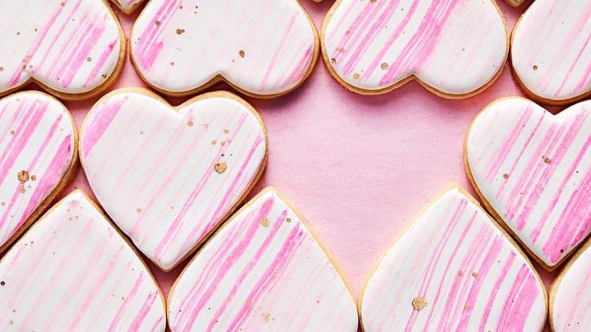 Arrange cookies end to end after dipping the tops in white icing. Let dry completely, then brush across them diagonally with pink frosting “paint.”