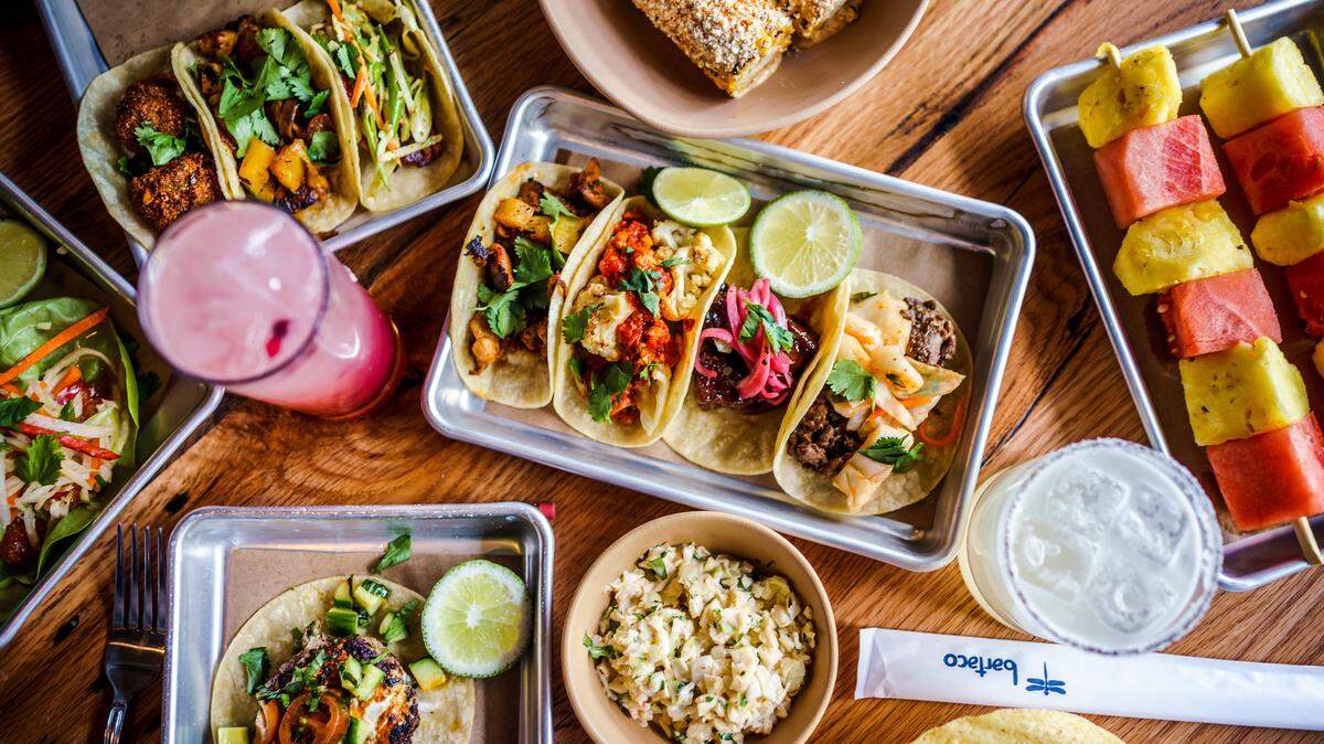 A selection of tacos and "non-taco" items at Bartaco. In the top left tray are falafel, chicken pastor and Yucatán redfish tacos; in the center tray are chicken pastor, cauliflower, pork belly and sesame ribeye tacos.