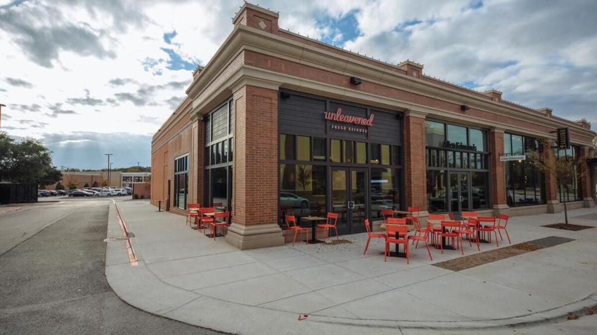 The Southlake Town Square location of Unleavened Fresh Kitchen with its sidewalk-seating tables.