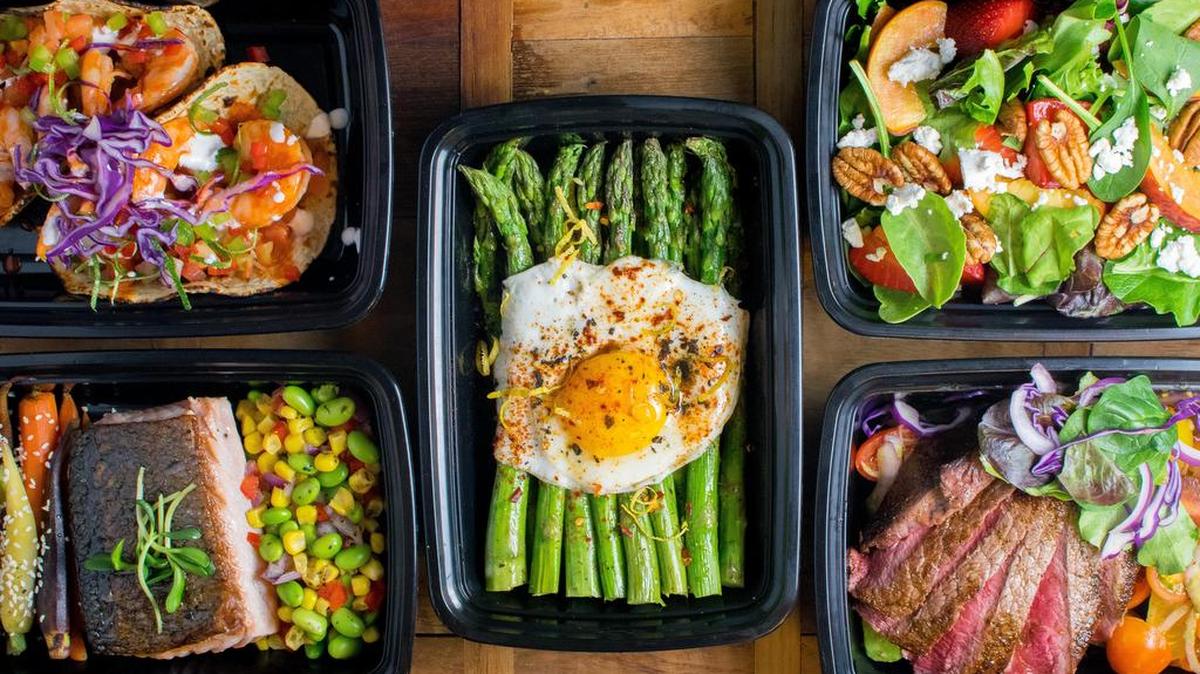 Some of Protein Fit Kitchen’s offerings: grilled shrimp tacos (top left), grilled salmon with heirloom carrot and Southern succotash, lemon asparagus (center), peaches and greens (top right), grilled sirloin with tomato salad