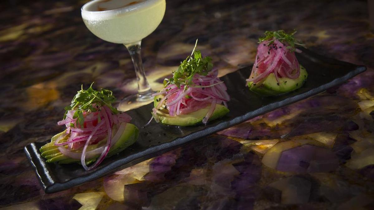Ahi avocado and a paloma cocktail at La Perla in a January photo. The downtown Fort Worth restaurant announced Tuesday on Facebook that it will close at the end of service Saturday.