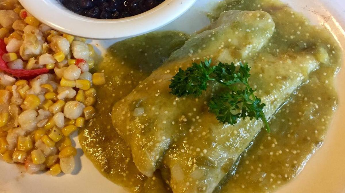 Los Vaqueros’ new “plant slant” vegetarian choices include avocado-onion enchiladas with hominy-corn relish and vegan black beans.