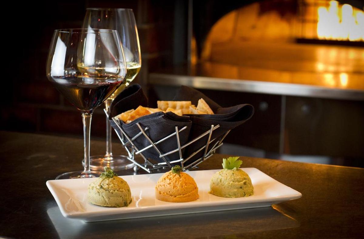 The hummus trio (jalapeño, roasted red pepper, and roasted garlic truffle) is a favorite at Winslow’s Wine Cafe.