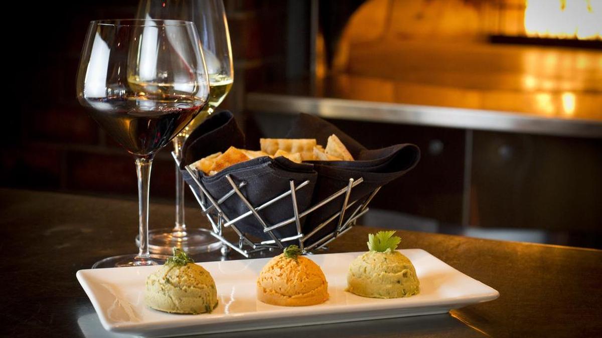 The hummus trio (jalapeño, roasted red pepper, and roasted garlic truffle) is a favorite at Winslow’s Wine Cafe.