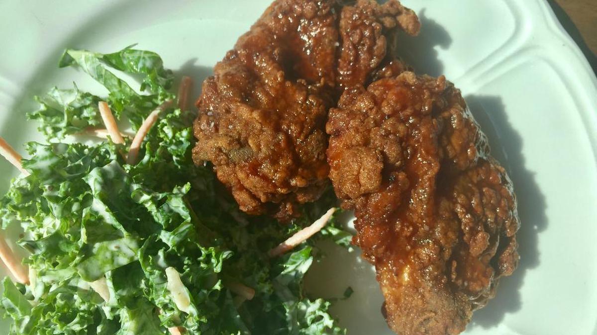 Fixe’s smoked-fried chicken thighs come with a kale salad.