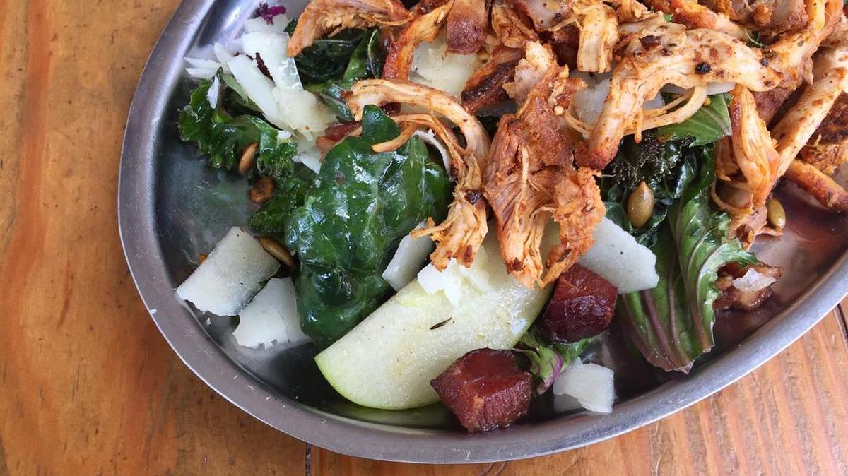 A three-kale salad with manchego, smoked chicken and guanciale (“Roman bacon”) at Woodshed Smokehouse.