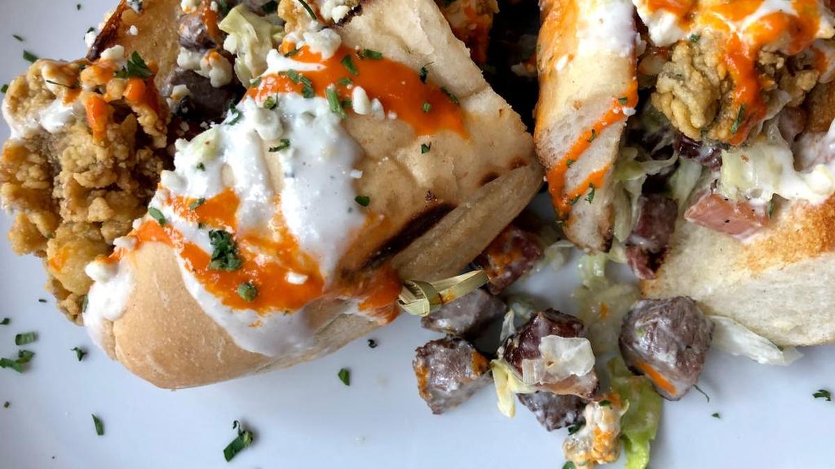 A fried oyster-beef tenderloin “Carpetbagger” po-boy with Buffalo sauce at B&B Butchers & Restaurant.