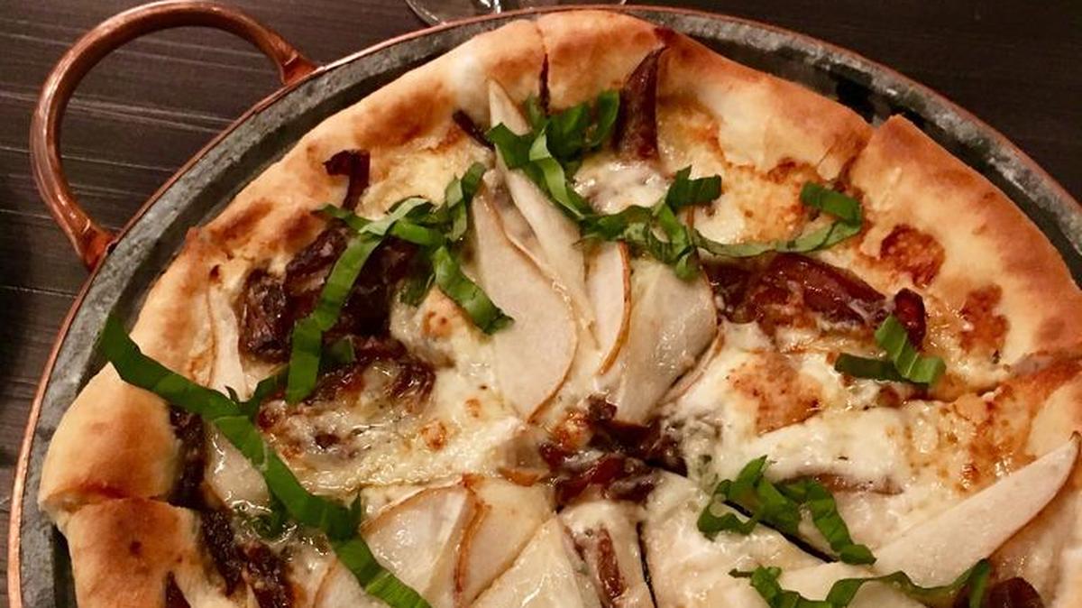 Crú’s fig and prosciutto pizza ($15), topped with fig jam, peppery arugula leaves and creamy fontina and Point Reyes blue cheeses
