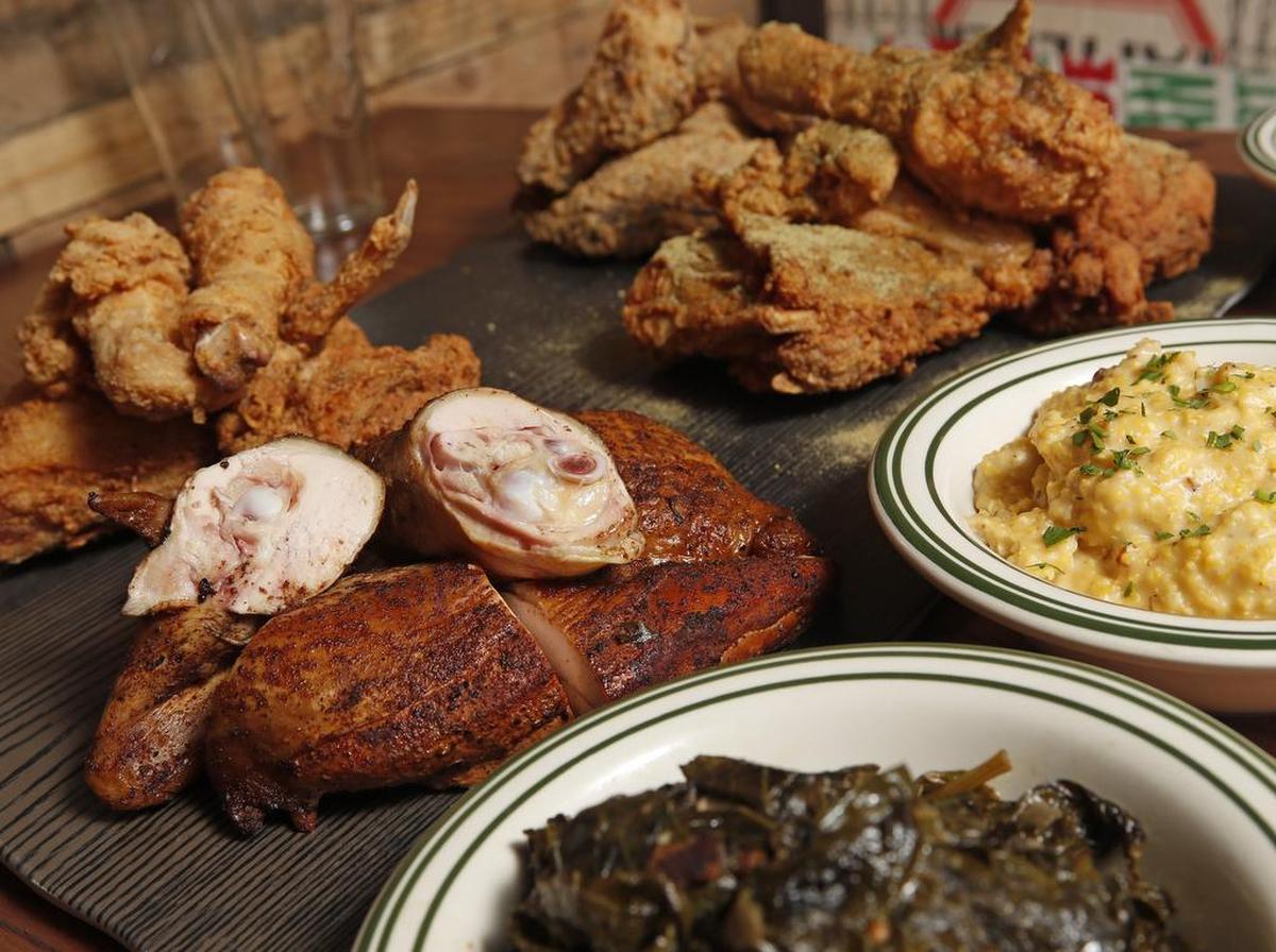 A board of chicken varieties with sides of greens and grits at Lewisville’s Prohibition Chicken.