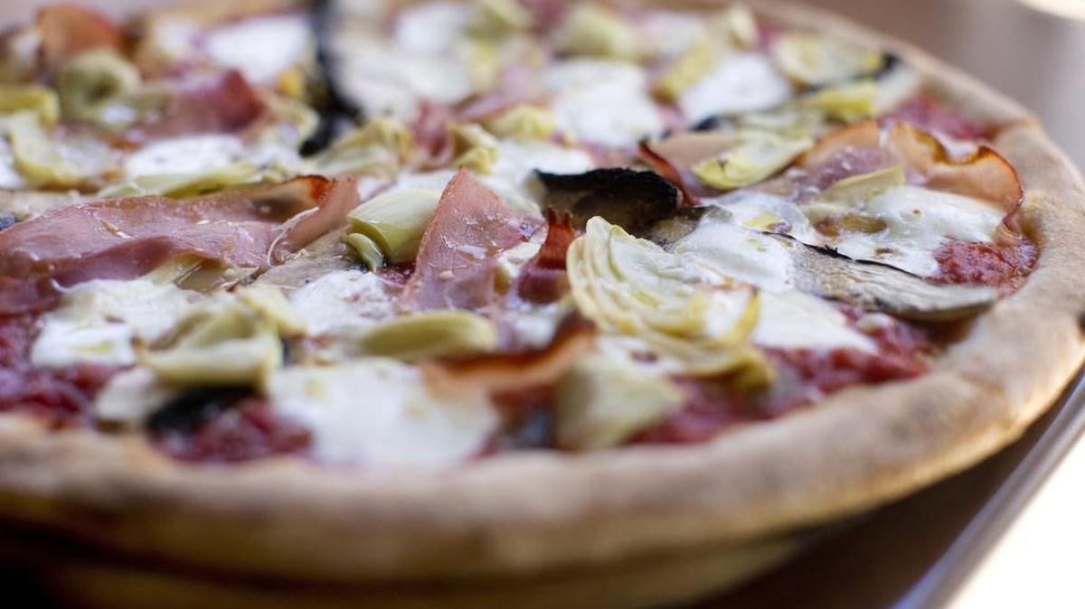 A pizza capricciosa (San Marzano tomatoes, fresh mozzarella, portobello mushrooms, artichokes, prosciutto di Parma, olive oil), fresh from the oven, at Ristorante Mulino in Southlake